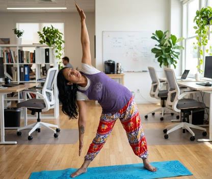Office worker doing desk yoga stretches to relieve tension and improve posture in the workplace