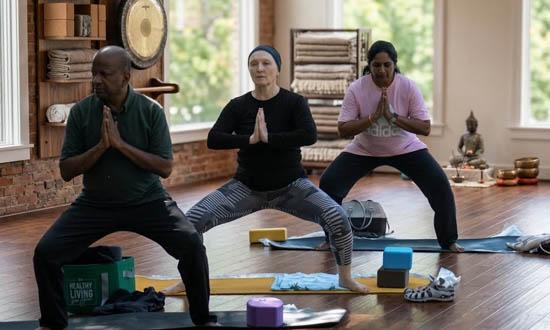 Employees participating in a workplace yoga and stress-relief stretching session during a corporate wellness program